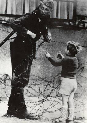 Grenzsoldat und Kind an der Stacheldrahtsperre am 13. August 1961