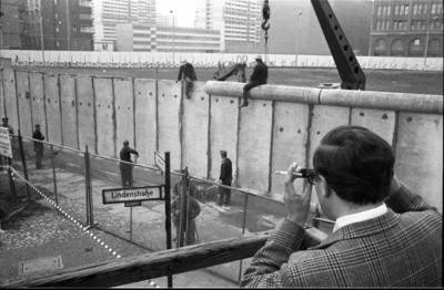 Ein Besucher einer Aussichtsplattform fotografiert das Anbringen der Rohrauflage auf die Grenzmauer 75 an der Zimmerstraße