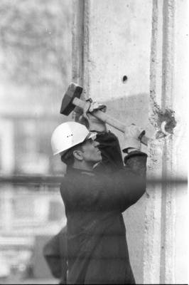 Bauarbeiter bearbeitet ein Mauerelement der Grenzmauer 75 am Pariser Platz
