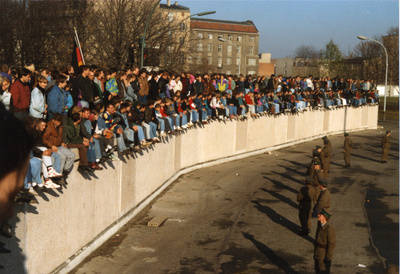 Grenzsoldaten überwachen die Menschenmassen auf der Grenzmauer am Brandenburger Tor