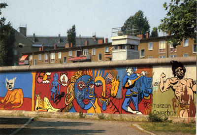 Wachturm im Grenzstreifen und Mauerkunst mit farbigen Köpfen am Bethaniendamm