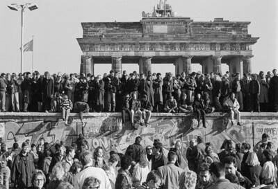 Feiernde Menschen auf der Grenzmauer am Brandenburger Tor