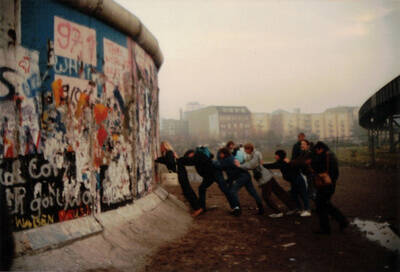 Touristengruppe probt Mauerumsturz am Potsdamer Platz