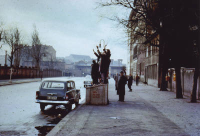 Gruppe winkender Menschen gegenüber Mauer des Sophienfriedhofs auf Bernauer Straße;